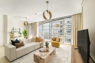 a living room with a white couch and a large window at Silkhaus Cityscape 2BR in DIFC Prime location in Dubai