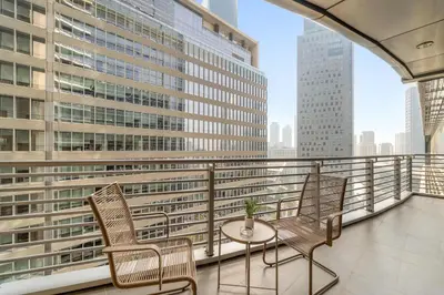 a balcony with two chairs and a table at Silkhaus Cityscape 2BR in DIFC Prime location in Dubai