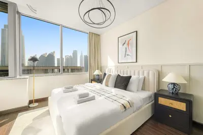 a white bedroom with a large bed and a large window at Silkhaus Premium 2BDR Stay in Sky Gardens DIFC in Dubai