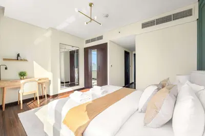 a bedroom with a white bed and a desk at Silkhaus Premium 2BDR Stay in Sky Gardens DIFC in Dubai