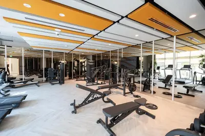 a gym with a lot of treadmills and machines at KeyRock Golf Gate - Relax and Unwind with Pool and Sauna in Dubai