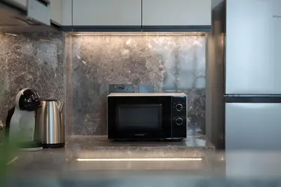 a microwave sitting on a counter in a kitchen at KeyRock Golf Gate - Stylish Retreat with Pool and Gym in Dubai