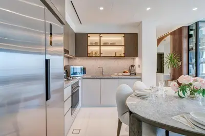 a kitchen with a table and a refrigerator at Beachfront Bliss 2Bedroom in Grand Bleu in Dubai