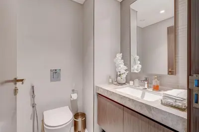 a bathroom with a toilet and a sink and a mirror at Beachfront Bliss 2Bedroom in Grand Bleu in Dubai