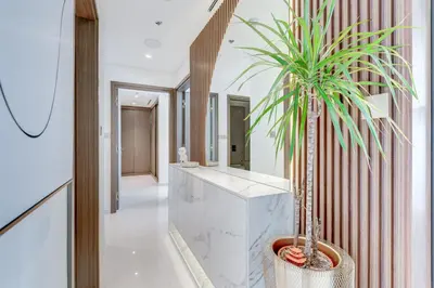 a house with a palm tree in a hallway at Beachfront Bliss 2Bedroom in Grand Bleu in Dubai