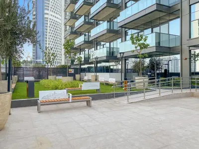 a park with benches in front of a building at Nobles tower tiger in Dubai