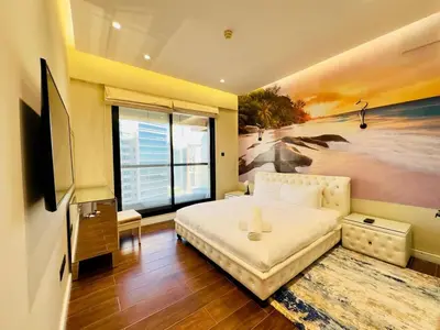 a bedroom with a bed and a painting of a beach at Upgraded High Rise 2 Br Full Marina Canal View in Dubai