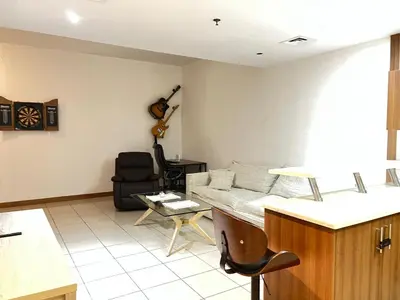 a living room with a couch and a guitar on the wall at Stylish 1 bedroom apartment with full kitchen in Dubai