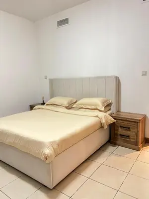 a bedroom with a large bed and a wooden table at Stylish 1 bedroom apartment with full kitchen in Dubai