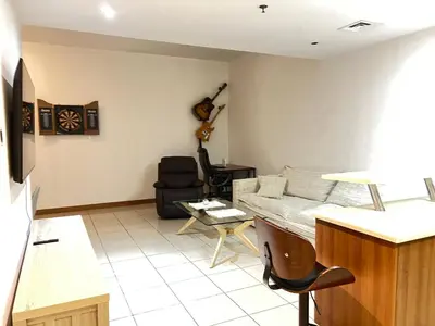 a living room with a couch and a chair at Stylish 1 bedroom apartment with full kitchen in Dubai