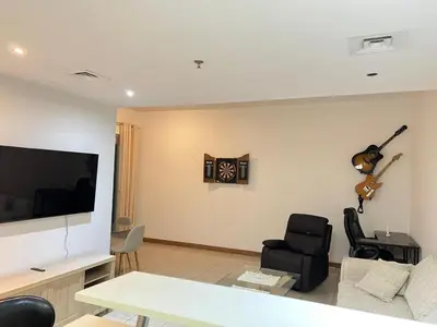 a living room with a tv and a table and chairs at Stylish 1 bedroom apartment with full kitchen in Dubai