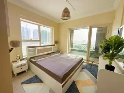 a bedroom with a large bed in a room with windows at Luxury 1 BHK in Dubai Marina By dPie Man 1011 in Dubai