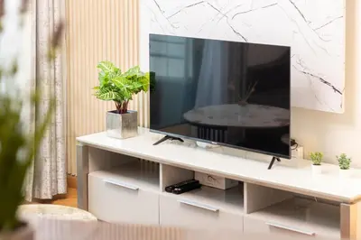 a television on a white stand in a living room at Luxury 1 BHK in Dubai Marina By dPie Man 1710 in Dubai