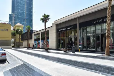 a shopping mall with palm trees in front of it at Modern & Spacious Studio in JBR in Dubai