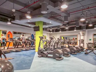 a gym with a lot of tread machines and people in it at Modern & Spacious Studio in JBR in Dubai