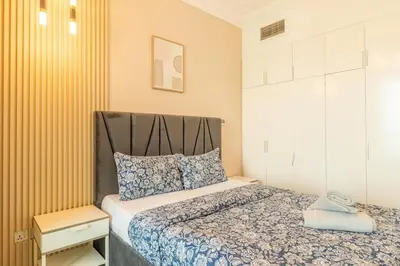 a small bedroom with a bed with blue and white sheets at Luxury 3BR in Dubai Marina Man 2203 in Dubai