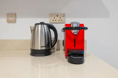a red blender sitting on a counter next to a coffee pot at Elegant 1B Missoni-Near Burj & Dubai Mall in Dubai