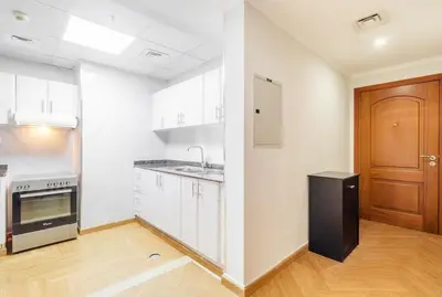 a kitchen with white cabinets and a black refrigerator at Luxury 2BR in Dubai Marina Man 405 in Dubai