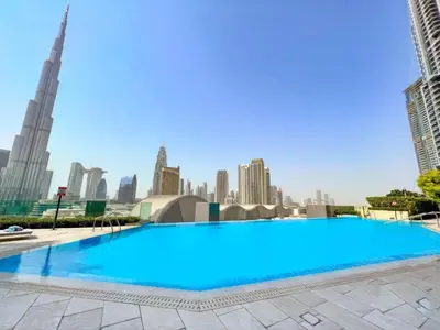 a large swimming pool with a city skyline in the background at Boulevard Point - One Bed with Burj Khalifa View in Dubai
