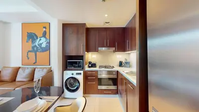 a kitchen with a table and a kitchen with a horse painting at Boulevard Point - One Bed with Burj Khalifa View in Dubai