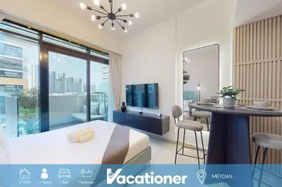 a bedroom with a bed and a table and a television at Azizi Riviera 18 - Peaceful Studio in Meydan in Dubai