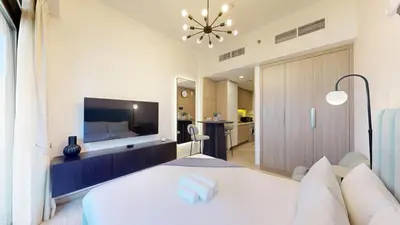 a bedroom with a large bed and a tv at Azizi Riviera 18 - Peaceful Studio in Meydan in Dubai