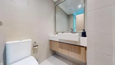 a bathroom with a sink and a toilet and a mirror at Azizi Riviera 18 - Peaceful Studio in Meydan in Dubai
