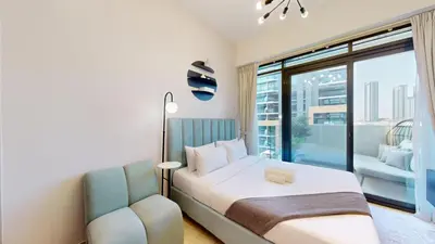 a bedroom with a bed and a chair and a window at Azizi Riviera 18 - Peaceful Studio in Meydan in Dubai