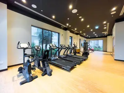a gym with a row of treadmills and ellipticals at Lotus Creek Beach - Opulent One Bed with Pool View in Dubai