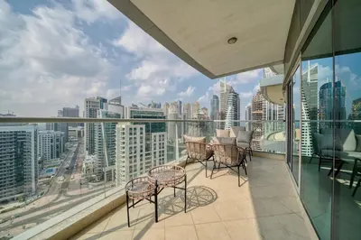 a balcony with chairs and tables and a view of the city at Cozy and Spacious 2Bedroom with Marina Bay view in Dubai