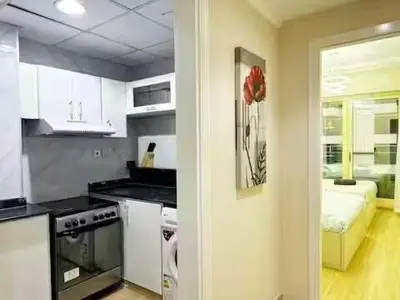 a kitchen with white cabinets and a room with a bed at Luxury 2BR in Dubai Marina Man 912 in Dubai