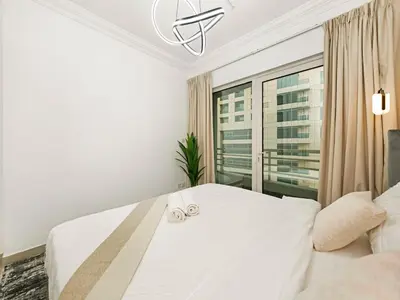 a bedroom with a large white bed with two towels on it at Luxury 3BHK w Floating Bed in Dubai Marina Man 2805 in Dubai