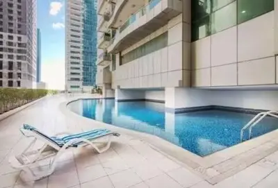 a swimming pool with a lounge chair and a building at Luxury 2BHK in Dubai Marina By dPie MP 1514 in Dubai