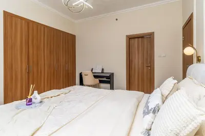 a bedroom with a large white bed and wooden cabinets at Luxury 2BHK in Dubai Marina w Views Sulafa 1101 in Dubai