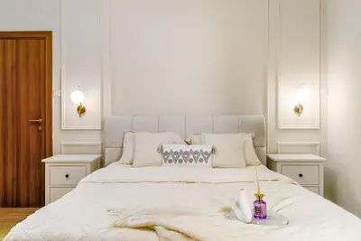 a white bedroom with a large bed with two night stands at Luxury 2BHK in Dubai Marina w Views Sulafa 1101 in Dubai
