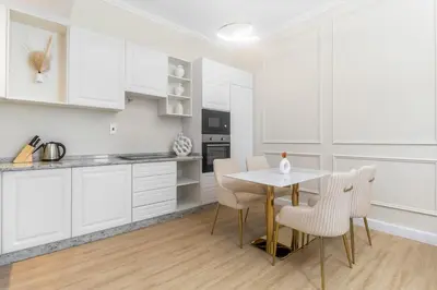 a kitchen with white cabinets and a table and chairs at Luxury 2BHK in Dubai Marina w Views Sulafa 1101 in Dubai