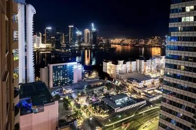 a view of a city at night from a building at Elegant 2BR - Stunning Sea Views & Prime Location in Dubai