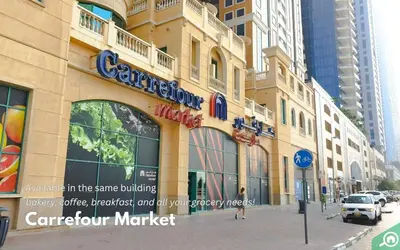 a building on a street with a car dealership market at Elegant 2BR - Stunning Sea Views & Prime Location in Dubai