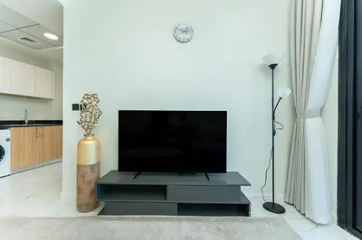 a living room with a television on a black entertainment center at PVH - Modern 1BR Near Metro - Alexis Tower in Dubai