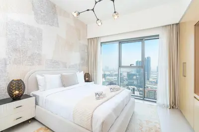 a bedroom with a bed and a large window at PVH - Canal View 1BR - Burj Royale in Dubai