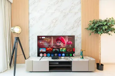 a television in a living room with a table at PVH - Canal View 1BR - Burj Royale in Dubai