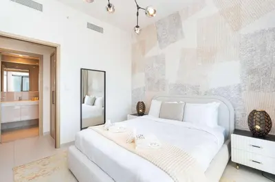 a bedroom with a large white bed and a mirror at PVH - Canal View 1BR - Burj Royale in Dubai