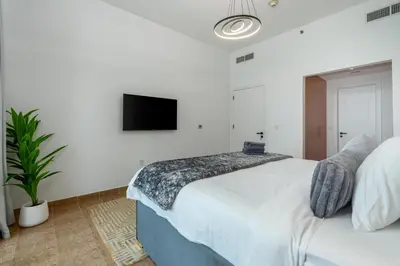 a bedroom with a bed and a tv on the wall at White Sage Newly Renovated 1BR Business Bay Hamilton Residency in Dubai