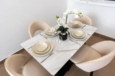 a white dining table with chairs and a white tablecloth at White Sage Newly Renovated 1BR Business Bay Hamilton Residency in Dubai