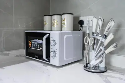 a white microwave on a counter with some kitchen utensils at White Sage Newly Renovated 1BR Business Bay Hamilton Residency in Dubai