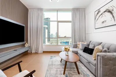 a living room with a couch and a tv at White Sage Newly Renovated 1BR Business Bay Hamilton Residency in Dubai