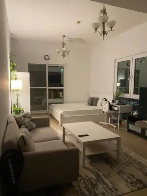 a living room with a bed and a couch and a table at Studio with homely cozy and positive vibes in Sabkhah