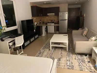 a living room and kitchen with a couch and a table at Studio with homely cozy and positive vibes in Sabkhah