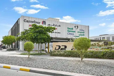 a large building with trees in front of it at Modern 1 Bedroom Apartment in Damac Hills 2 in Dubai