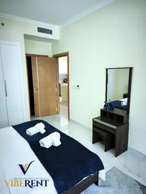 a bedroom with a bed and a mirror and a sink at Modern 1BR Apartment with Pool & Gym, 15 Min to JBR in Dubai